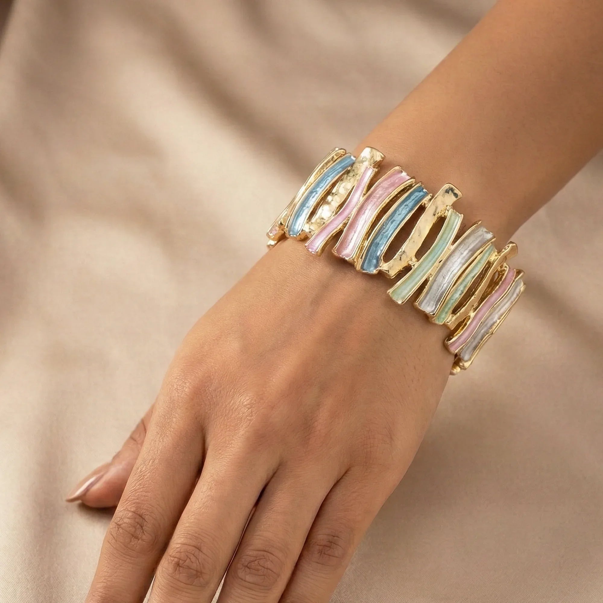 Multicolored bracelet on a hand against a beige background