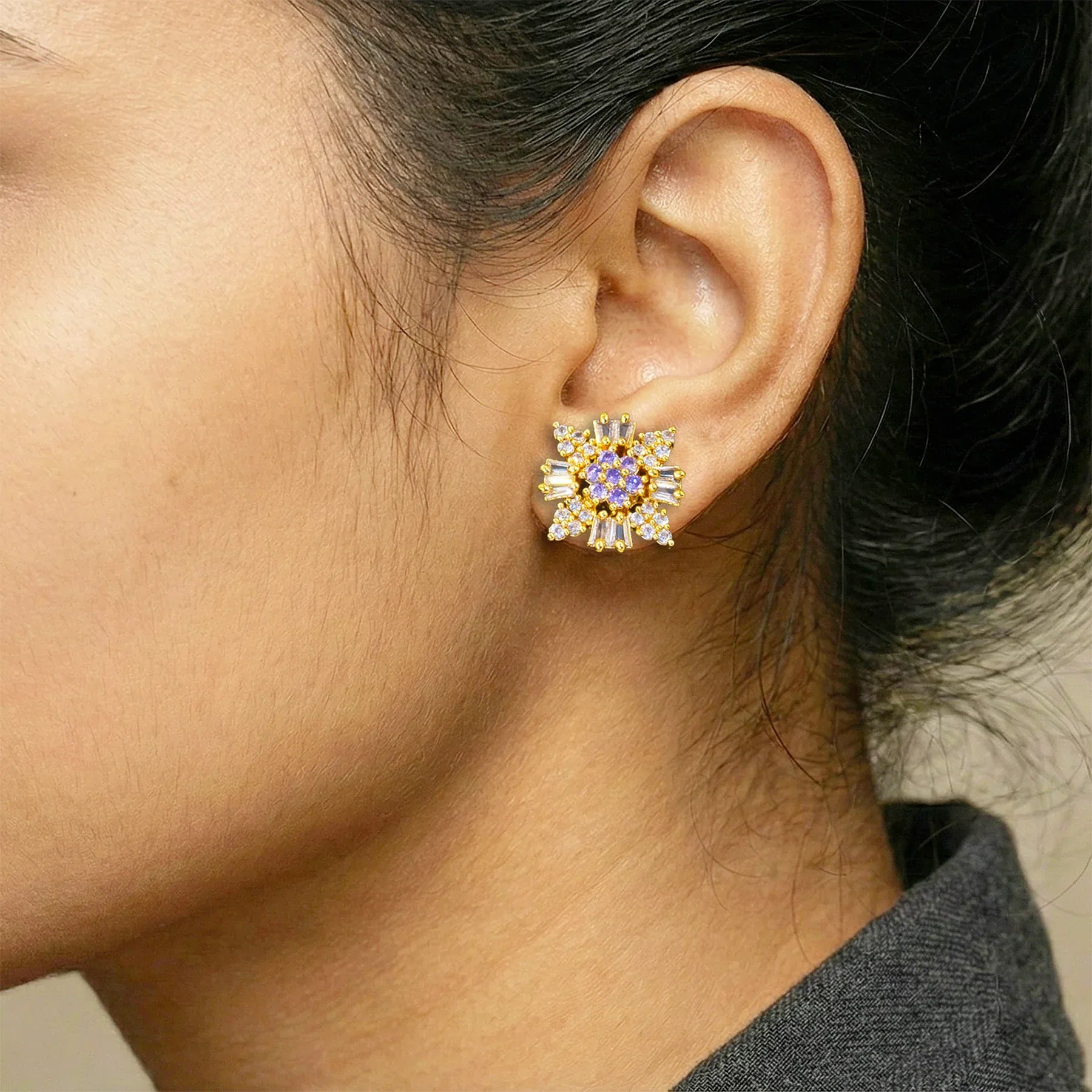 Close-up of an ear wearing a decorative earring with a blurred background