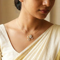 Woman wearing a gold necklace with a decorative pendant